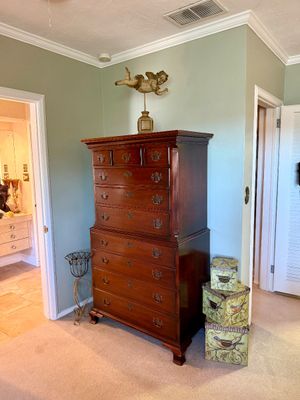 Traditional mahogany chest-on-chest tallboy dresser with batwing brass bail handles, displayed alongside a cherub sculpture and...