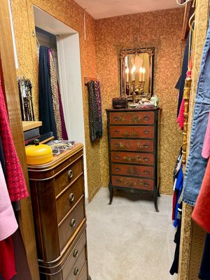 Walk-in dressing area featuring a hand-painted Asian Chinoiserie tallboy chest, an ornate wall mirror with a candelabra lamp, and a...