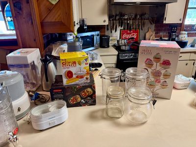 Assorted kitchenware and small appliances, including glass storage jars with wire bail closures, a Citrus Express juicer in its original...