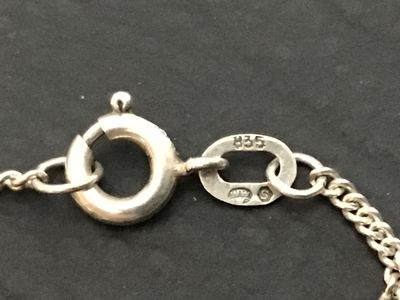 Sale Photo Thumbnail #133: A fine silver necklace featuring a puffed heart pendant. The pendant bail is stamped '925' for sterling silver, while the chain clasp tag is stamped '835' alongside a maker's mark/hallmark. Features a curb chain with a spring ring clasp. Shows light tarni