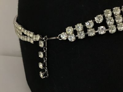 Sale Photo Thumbnail #80: Vintage silver-tone costume jewelry piece featuring three rows of prong-set clear round rhinestones. Includes a hook closure and extension tail. Versatile design can be worn as a choker necklace or a waist belt depending on measurements. Good vintage cond