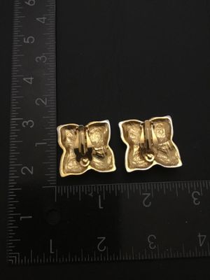 Sale Photo Thumbnail #132: Pair of bold vintage clip-on statement earrings featuring pave-set clear rhinestones in a four-petal or four-point star shape with gold-tone accents. Clip-on backs are functional. Each earring measures approximately 1.25 inches across. Good pre-owned vint