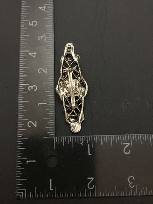 Sale Photo Thumbnail #196: A silver-tone metal brooch featuring detailed openwork filigree, floral motifs, and a central round faux pearl/cabochon accent. Measures approximately 2.25 inches long by 0.75 inches wide. Features a standard pin back with clasp. Good condition with light