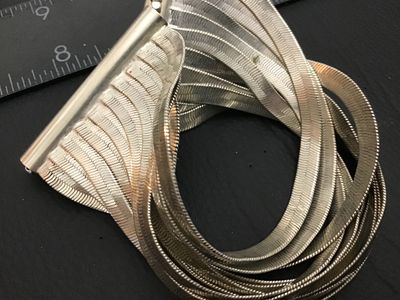 Sale Photo Thumbnail #140: A Kenneth Cole wide cuff bracelet featuring multiple flexible silver-tone herringbone chains gathered into polished metallic end bars with beaded accents. Marked Kenneth Cole on the clasp bar. Shows light wear consistent with pre-owned condition.