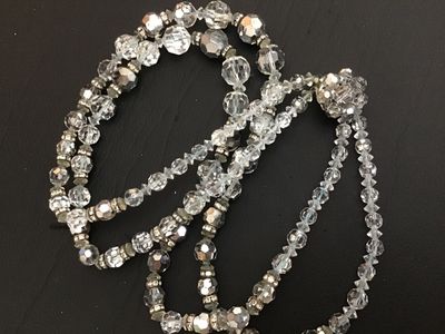 Sale Photo Thumbnail #55: A vintage double-strand necklace featuring faceted clear crystal glass beads accented with rhinestone rondelle spacers and a decorative crystal cluster clasp. Shows mid-century styling. Good condition with light vintage wear visible on the spacer metals.