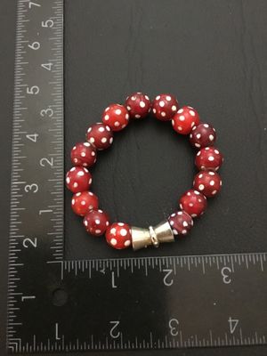 Sale Photo Thumbnail #236: A stretch bead bracelet featuring red Venetian glass 'skunk' beads with white polka dot spots, accented by a silver-tone metal bead. The bracelet measures approximately 2.5 inches in inner diameter. Shows minor age-appropriate wear and slight imperfection