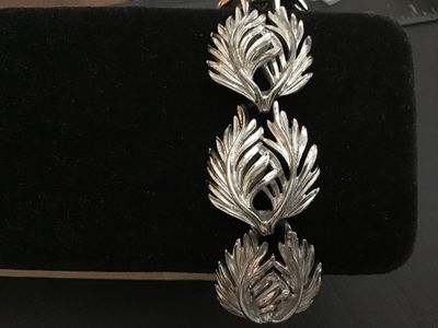 Sale Photo Thumbnail #187: A vintage Lisner silver-tone costume jewelry link bracelet featuring textured feather/leaf-shaped links and a fold-over clasp. Signed 'LISNER©' on the clasp. Measures approximately 7.5 inches in total length. Overall good vintage condition with light fin