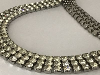 Sale Photo Thumbnail #84: Vintage silver-tone costume jewelry piece featuring three rows of prong-set clear round rhinestones. Includes a hook closure and extension tail. Versatile design can be worn as a choker necklace or a waist belt depending on measurements. Good vintage cond