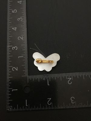 Sale Photo Thumbnail #108: Vintage carved mother of pearl butterfly brooch featuring carved shell wings, thin wire antennae, and a gold-tone pin bar back. Measures approximately 1.25 inches wide by 1 inch tall. In good pre-owned condition with functional clasp.