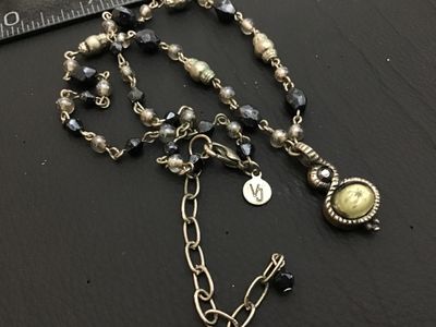 Sale Photo Thumbnail #145: A beaded costume jewelry necklace featuring faceted black and smoky beads, silver-tone metal links, and a drop pendant with a yellowish faux pearl cabochon and a small dark rhinestone accent. Includes a lobster claw clasp, an extender chain, and a circula
