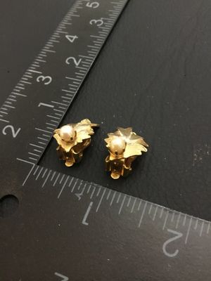 Sale Photo Thumbnail #185: Pair of vintage gold-tone textured leaf clip-on earrings, each accented with a faux pearl center. Each earring measures approximately 3/4 inch long by 1/2 inch wide. Clip backs are in good working order. Good pre-owned condition with minor vintage wear.