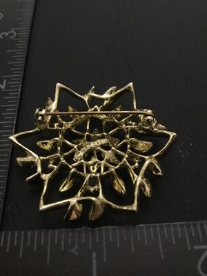 Sale Photo Thumbnail #35: Vintage Sarah Coventry gold-tone openwork floral brooch pin featuring textured leaf and petal details. Measures approximately 1.75 inches in diameter. Signed Sarah Coventry on the back. Includes a standard pin back with a safety clasp mechanism. In good v