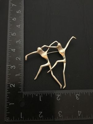 Sale Photo Thumbnail #89: A vintage silver-tone modernist brooch depicting two abstract dancing figures, manufactured by American Jewelry Chain Co. (marked AJC). Features a rollover safety clasp on the back. Measures approximately 2.5 inches wide by 2.25 inches high as shown again