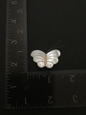 Sale Photo Thumbnail #105: Vintage carved mother of pearl butterfly brooch featuring carved shell wings, thin wire antennae, and a gold-tone pin bar back. Measures approximately 1.25 inches wide by 1 inch tall. In good pre-owned condition with functional clasp.