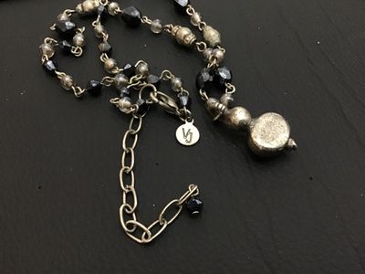 Sale Photo Thumbnail #151: A beaded costume jewelry necklace featuring faceted black and smoky beads, silver-tone metal links, and a drop pendant with a yellowish faux pearl cabochon and a small dark rhinestone accent. Includes a lobster claw clasp, an extender chain, and a circula