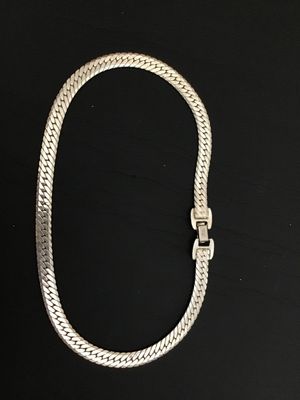 Sale Photo Thumbnail #111: A vintage silver-tone flat herringbone chain necklace by Napier. Features a secure fold-over clasp marked 'Napier PAT. 4,774,743' and 'NAPIER©'. The piece shows a classic flat-link woven design with a shiny finish. In good vintage condition with minor su