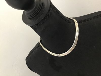 Sale Photo Thumbnail #107: A vintage silver-tone flat herringbone chain necklace by Napier. Features a secure fold-over clasp marked 'Napier PAT. 4,774,743' and 'NAPIER©'. The piece shows a classic flat-link woven design with a shiny finish. In good vintage condition with minor su