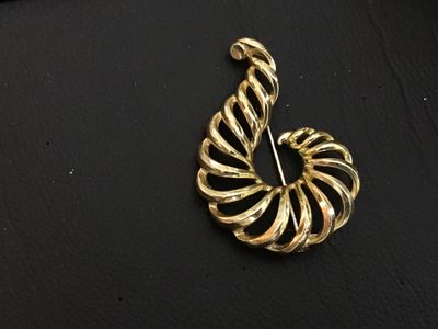 Sale Photo Thumbnail #186: A vintage gold-tone costume jewelry brooch featuring an openwork spiral shell or swirl design. Marked 'LISNER' on the back. Features a standard pin mechanism with rolling C-clasp. Shows light pre-owned wear consistent with age.