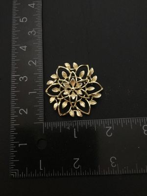 Sale Photo Thumbnail #31: Vintage Sarah Coventry gold-tone openwork floral brooch pin featuring textured leaf and petal details. Measures approximately 1.75 inches in diameter. Signed Sarah Coventry on the back. Includes a standard pin back with a safety clasp mechanism. In good v
