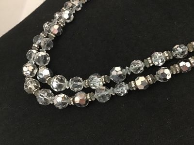 Sale Photo Thumbnail #53: A vintage double-strand necklace featuring faceted clear crystal glass beads accented with rhinestone rondelle spacers and a decorative crystal cluster clasp. Shows mid-century styling. Good condition with light vintage wear visible on the spacer metals.