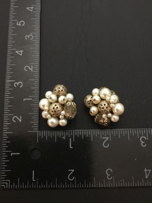 Sale Photo Thumbnail #221: Pair of vintage cluster clip-on earrings featuring faux pearls, faceted glass beads, and gold-tone pierced filigree beads set on filigree backing plates. Each earring measures approximately 1 inch in diameter. Clip backs function properly. Shows mild age-