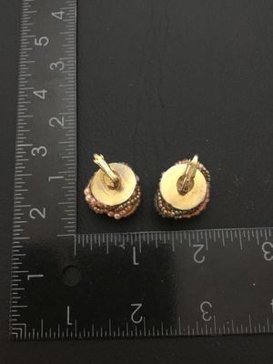 Sale Photo Thumbnail #159: Pair of vintage clip-on cluster earrings featuring woven seed beads and faux pearls in shades of peach, grey, and metallic tones on gold-tone backing plates. Each earring measures approximately 1 inch in diameter. In good vintage condition with secure cli