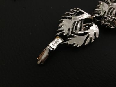 Sale Photo Thumbnail #191: A vintage Lisner silver-tone costume jewelry link bracelet featuring textured feather/leaf-shaped links and a fold-over clasp. Signed 'LISNER©' on the clasp. Measures approximately 7.5 inches in total length. Overall good vintage condition with light fin