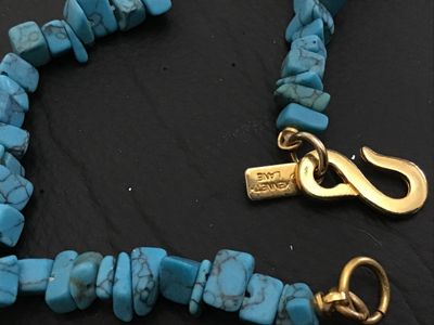 Sale Photo Thumbnail #200: Signed Kenneth Jay Lane necklace featuring turquoise-colored stone chips with gold-tone metal findings and S-hook clasp. Measures approximately 32 inches in total length. Good vintage condition with no visible damage.