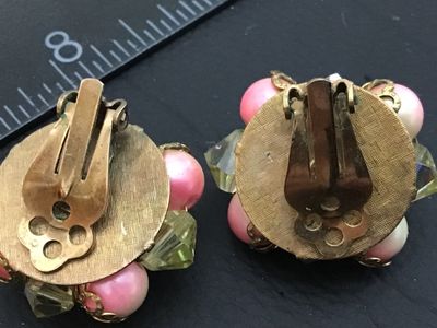 Sale Photo Thumbnail #100: Pair of vintage cluster-style clip-on earrings featuring yellow iridescent Aurora Borealis crystal beads, pink center beads, and faux pearls in gold-tone metal settings. Each earring measures approximately 1 inch in diameter. Clips show light metal oxidat
