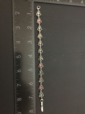 Sale Photo Thumbnail #206: A silver-tone link bracelet featuring connected butterfly links inlaid with colorful crushed shell / abalone inlay. Measures approximately 7 inches long end-to-end with a fold-over clasp. Good condition with minimal signs of wear.