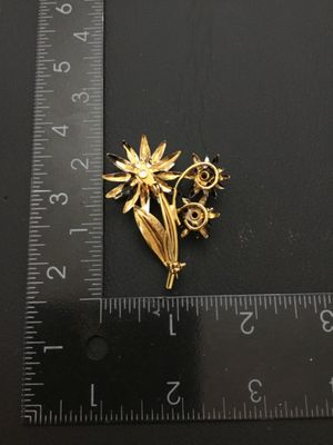 Sale Photo Thumbnail #217: Vintage mid-century style floral spray brooch featuring black enameled flower blossoms and textured gold-tone leaves. Measures approximately 2 inches long by 1.5 inches wide. Overall good vintage condition with pin back clasp in working order; minor ename