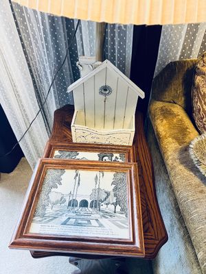 Pair of framed black-and-white architectural prints displayed next to a white birdhouse-style wooden organizer on an oak side table.