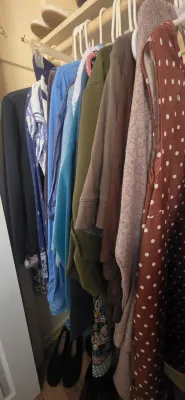 Sale Photo Thumbnail #42: Closet filled with assorted women's clothing on plastic hangers, including a rust polka dot dress, sweaters, and blouses.