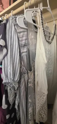 Sale Photo Thumbnail #39: Selection of women's casual tops hanging in a closet, featuring striped, lace-trimmed, and embroidered designs.