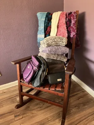Sale Photo Thumbnail #45: Collection of women's winter accessories, knit sweaters, scarves, and handbags displayed on a vintage wooden armchair.