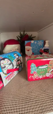 Sale Photo Thumbnail #18: Collection of festive holiday decor including a penguin-themed mailbox tin, gingerbread tin, Santa Claus jar, and related Christmas items.