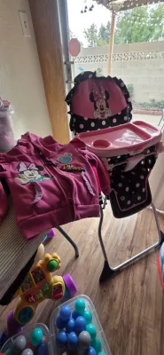 Sale Photo Thumbnail #8: Disney Minnie Mouse toddler high chair featuring pink and black polka dots, paired with a matching pink Minnie Mouse zip-up hoodie.