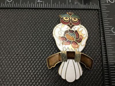Sale Photo Thumbnail #98: Vintage cloisonné enamel brooch featuring a detailed owl perched on a branch. Styled in colorful enamel with gold-tone outlines including white, gold, burgundy, teal, and brown accents. Measures approximately 2 inches in length. Features a standard pin b