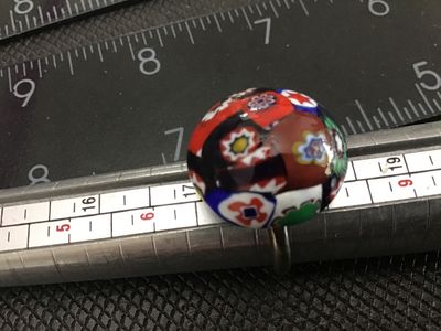 Sale Photo Thumbnail #136: Vintage costume jewelry ring featuring a colorful millefiori art glass cabochon in red, blue, green, white, and black tones. Set on a silver-tone adjustable metal band. The ring shows normal vintage wear with slight tarnish/patina on the metal band and gl