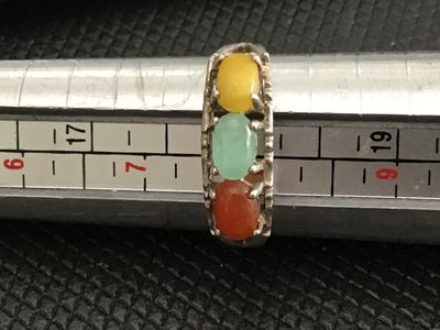 Sale Photo Thumbnail #198: Sterling silver band featuring three oval cabochons in yellow, green, and orange/red tones, possibly multi-colored jade or chalcedony. Inner band is stamped with a maker mark and sterling/925 purity mark. Measures approximately size 7.5 on a ring sizer. S