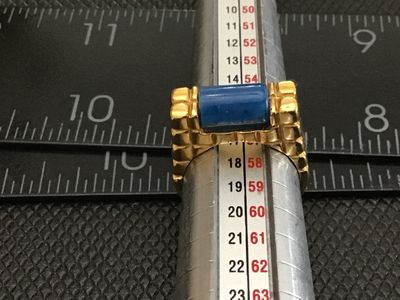 Sale Photo Thumbnail #11: Gold-tone fashion statement ring featuring a textured waffle/grid band design set with a cylindrical blue stone resembling lapis lazuli or sodalite. Ring measures approximately size 7.5 on a ring mandrel. Good pre-owned condition with light surface wear v