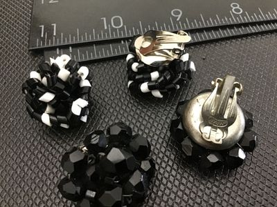 Sale Photo Thumbnail #10: Lot of two pairs of vintage clip-on cluster earrings. Includes one pair of black and white woven tube bead cluster earrings and one pair of faceted black glass/bead cluster earrings marked 'JAPAN' on the clip hardware. Both pairs measure approximately 1 i