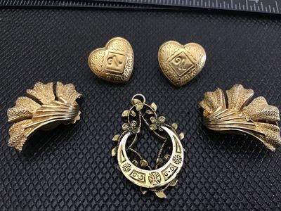 Sale Photo Thumbnail #52: A 5-piece assortment of gold-tone vintage fashion jewelry, including:
- Pair of heart-shaped pierced stud earrings with embossed scroll detail
- Pair of textured fan-shaped clip-on earrings
- Openwork floral horseshoe/teardrop pendant with bail

Condition