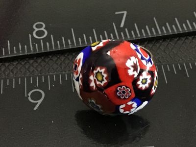 Sale Photo Thumbnail #138: Vintage costume jewelry ring featuring a colorful millefiori art glass cabochon in red, blue, green, white, and black tones. Set on a silver-tone adjustable metal band. The ring shows normal vintage wear with slight tarnish/patina on the metal band and gl