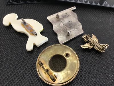Sale Photo Thumbnail #186: Assorted vintage costume jewelry brooch pins, set of 4. Includes a plastic novelty pink flamingo brooch, a rhinestone-adorned American flag pin, a small praying angel pin, and a circular metallic brooch with a mesh center ). Items show light pre-owned sur