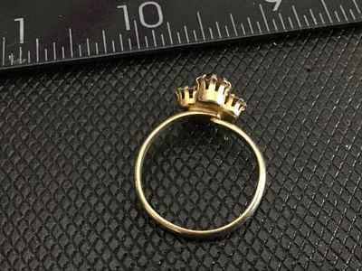 Sale Photo Thumbnail #213: Vintage gold-tone fashion ring featuring four prong-set stones arranged in a cluster: two faceted red/ruby-colored rhinestones and two clear rhinestones. Shows light surface wear and slight tarnish on the metal band consistent with age. Measures approxima
