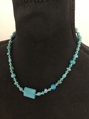 Sale Photo Thumbnail #109: Beaded strand necklace featuring assorted turquoise-colored stone beads, chips, and a central focal bead, interspersed with small gold-tone spacer beads. Finished with a gold-tone lobster claw clasp. Good pre-owned condition with no visible damage.