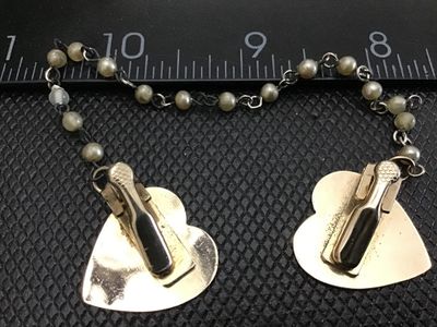 Sale Photo Thumbnail #45: Vintage gold-tone sweater clip / collar guard featuring polished heart-shaped clips connected by a double-linked chain set with faux pearl beads. Measures approximately 4.5 to 5 inches in total length. Clips show light metal wear and tarnish appropriate f
