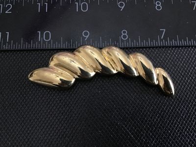 Sale Photo Thumbnail #236: A vintage gold-tone costume jewelry brooch featuring a stylized ribbed or twisted swirl design with a polished finish and textured back. Fitted with a standard pin stem and rollover safety clasp. Measures approximately 3 inches in length. In good vintage 