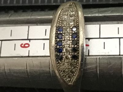 Sale Photo Thumbnail #64: Sterling silver band ring featuring a pavé-set top face with rows of blue and clear rhinestones/cz stones. Stamped 925 on the interior band. Measures approximately ring size 6 on a ring mandrel. Shows light surface wear and minor tarnishing consistent wi